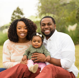 Mum and Dad holding little girl and sat as a family