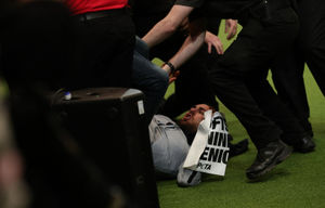 An intruder is wrestled to the ground after Tease, the Whippet, was named Supreme Champion during the final day of Crufts