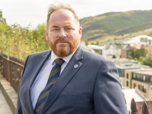 Craig Naylor with view of buildings and hillside behind him