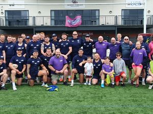 Players, staff and volunteers pose together following the event