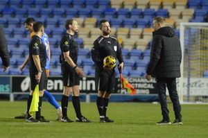 Harrogate Town boss Simon Weaver speaks with match officials after defeat to Shrewsbury Town