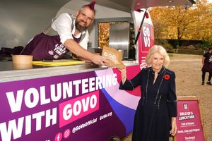 TikTok star Spudman serves food to Queen Camilla, from 'The Role of a Lunchtime' street food truck as they discuss volunteering roles available through the charity Royal Voluntary Service's new digital volunteering platform, GoVo, during an event to celebrate community volunteering, at Clarence House in central London. Photo credit: Jordan Pettitt/PA Wire
