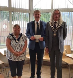 Tim from Llandrindod Wells Silver Band with their cheque with Llandrindod Wells Mayor and Deputy Mayor