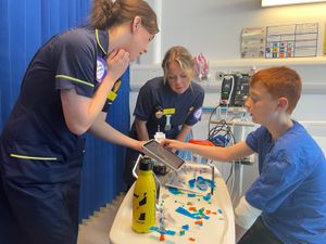 Esme Griffiths, left, and Rachel Bennett, right, with a patient showing them the new digital system.