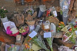 A paid of sunglasses can be seen among the rubble of the broken brick wall