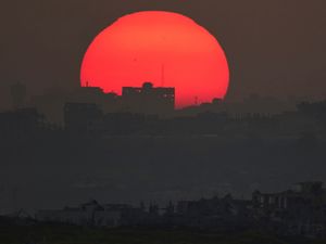 The sun sets behind buildings destroyed during an Israeli air and ground offensive in the Gaza Strip