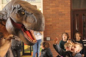 The animatronic dinosaur pays children at the library a visit. Photo by Maddy Forster