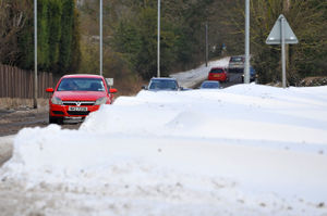 A car drives past a huge snow drift along A34 near Cannock