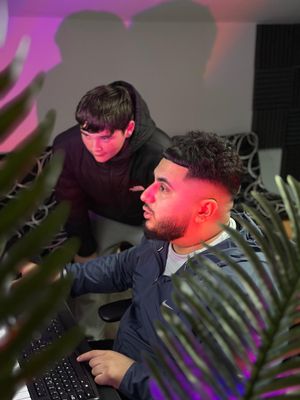 Producer S Finesse mentors a young participant during a studio session.