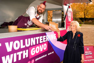 TikTok star Spudman serves food to Queen Camilla, from 'The Role of a Lunchtime' street food truck as they discuss volunteering roles available through the charity Royal Voluntary Service's new digital volunteering platform, GoVo, during an event to celebrate community volunteering, at Clarence House in central London. Photo credit: Jordan Pettitt/PA Wire