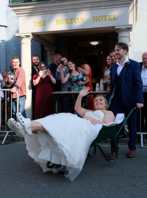 Bride and groom Sarah and Drew Carter joined the fun by posing with a wheelbarrow during their wedding at the Burton Hotel