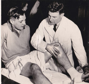 Jack Davies in his other role as club physiotherapist treating Jimmy Mullen
