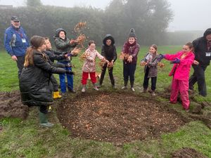Pupils from Clee Hill Community Academy celebrating the end of the mucky task of crocus corn plating