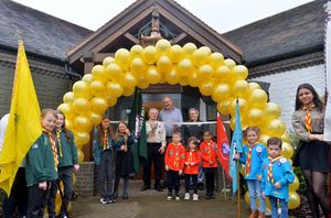 Scout leader Don Welch gets ready to cut a ribbon to mark the reopening