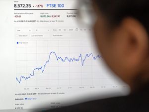 A woman views the FTSE 100 index on the London Stock Exchange website.