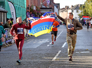 Two Oswestry runners with a We Stand With Ukraine flag