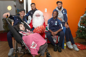 Father Christmas and the players give a present to Hadiqa Arif. Photo: AMA
