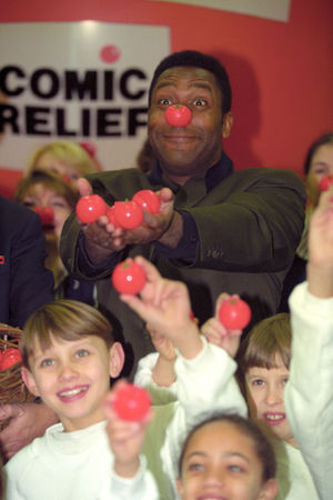 Sir Lenny Henry models the tomato-shaped Red Nose