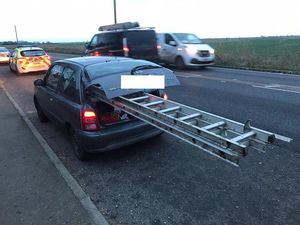 Supporting image for story: Police take steps to halt progress of small car carrying long ladder