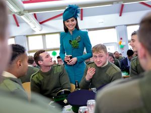 The Princess of Wales holding a glass of Guinness while visiting the Irish Guards