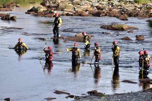 Search and rescue crews wade through the River Esk