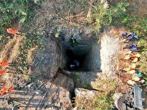 Rescue workers stand around a coal mine where at least nine workers are trapped in the Dimapur Hasao district in the north-eastern state of Assam, India