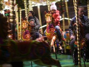 A small girl is pictured riding on a carousel at the German Christmas Market in Birmingham