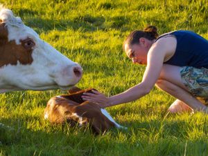 Casha Bowles-Jones with a newborn calf from the cow and calf dairy herd.
