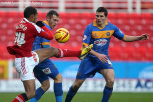 Jon Taylor and David McAllister of Shrewsbury Town battle with Jamie Reckord of Swindon Town