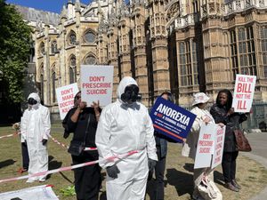 Protesters hold up signs which read "don't prescribe suicide" and "anorexia is not a terminal illness" in Westminster