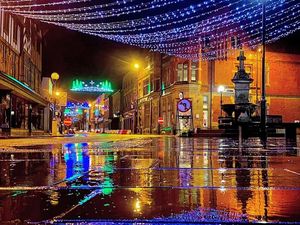 Supporting image for story: Reflections on Christmas as lights are mirrored on wet pavements