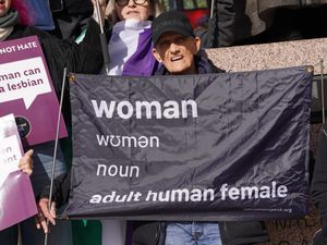 Campaigner with a sign saying a woman is a an adult human female