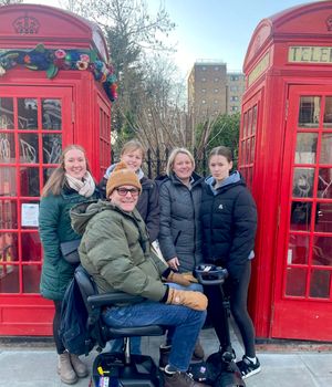 Dylan in his mobility scooter with (left to right) stepdaughter Megan, Ameila, Louise and Ella Rose on a recent trip to London

