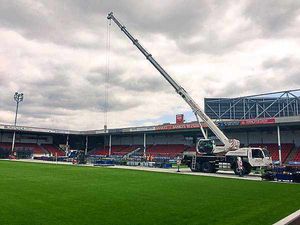 A crane next to the Banks's Stadium pitch helping to build the stage Sir Elton John will be performing on during the show