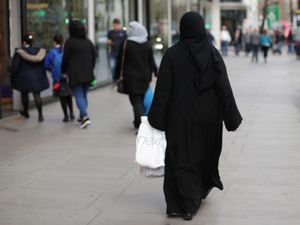 A general view of a Muslim woman walking on a high street in London