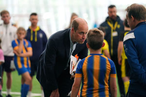The Prince of Wales talks to youngsters in Shrewsbury Town shirts during his visit to St George's Park
