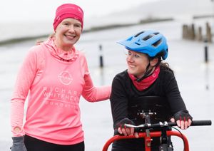 Volunteer Gill Menzies (pink top), who is helping her friend Julie McElroy (black top) become the first female frame runner to complete the TCS London Marathon