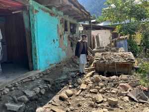 A Kashmiri villager examines his damaged house