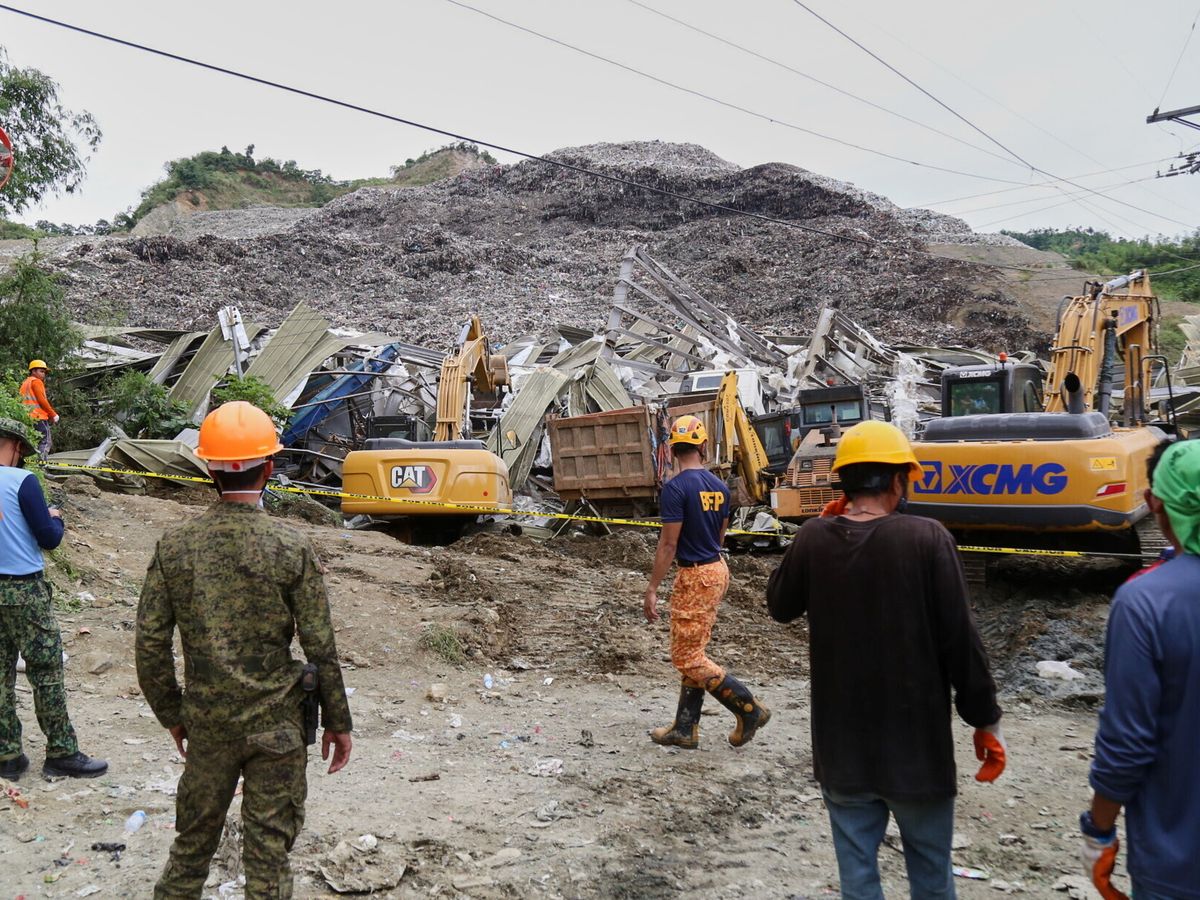 Two dead and dozens missing after mountain of rubbish collapses in Philippines