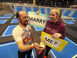 The happy couple with placards that were used as part of the proposal