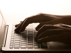 Hands on a laptop keyboard