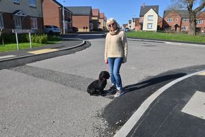 Lin Glover and her dog Hattie. Lin has voiced frustration at the unfinished state of the estate's roads.