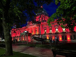 A Spitfire parked in front Belfast City Hall which has been lit up red