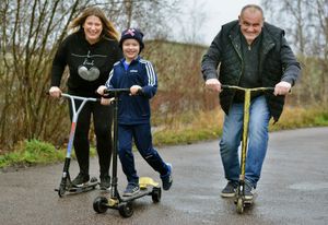 George Handley is taking on a marathon challenge to help people suffering with cancer. He is seen on his scooter with parents Claire and Martyn Handley