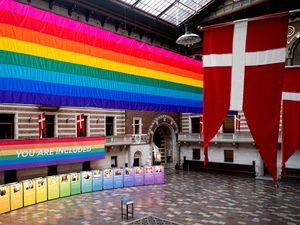 A rainbow flag next to a Danish flag at Copenhagen City Hall