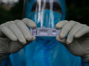 A health worker shows a Covid-19 positive test during a door-to-door test drive in Gauhati, India
