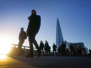 City workers walk across a bridge in London