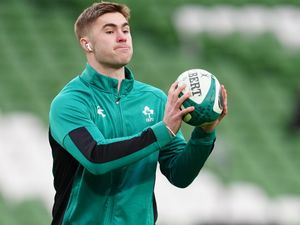 Jack Crowley, wearing headphones, catches the ball