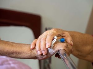 Elderly hands on hospital bed