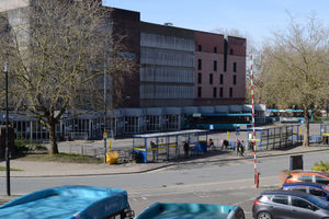 A handful of passengers for the buses at the bus station.